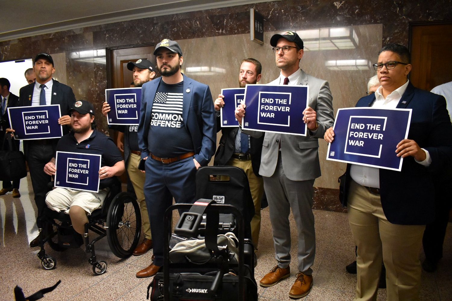 Alexander McCoy with veterans holding End the Forever War signs at the Capitol